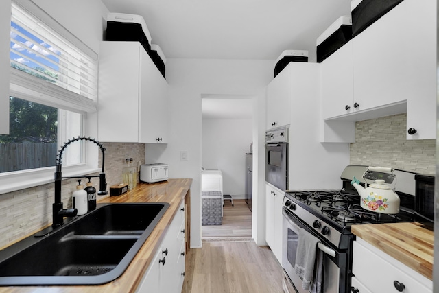 2626 Garfield St, Hollywood, FL 33020 - kitchen featuring appliances with stainless steel finishes, wood counters, backsplash, and white cabinets