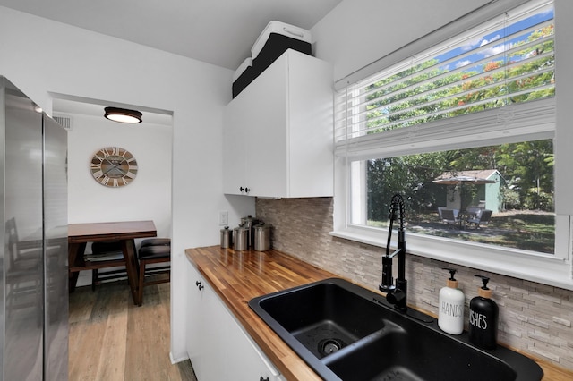 2626 Garfield St, Hollywood, FL 33020 - kitchen featuring wooden counters, white cabinets, healthy amount of natural light, and freestanding refrigerator