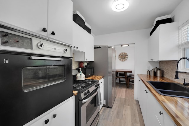 2626 Garfield St, Hollywood, FL 33020 - kitchen with wood counters, black appliances, tasteful backsplash, and white cabinets