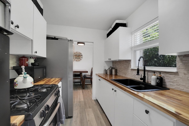 2626 Garfield St, Hollywood, FL 33020 - kitchen featuring butcher block countertops, stainless steel range with gas cooktop, and white cabinets