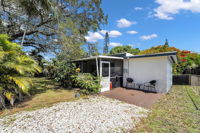 2626 Garfield St, Hollywood, FL 33020 - back of house featuring a sunroom, stucco siding, and a patio