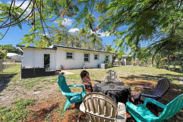 2626 Garfield St, Hollywood, FL 33020 - rear view of house with a fire pit, stucco siding, and a fenced backyard