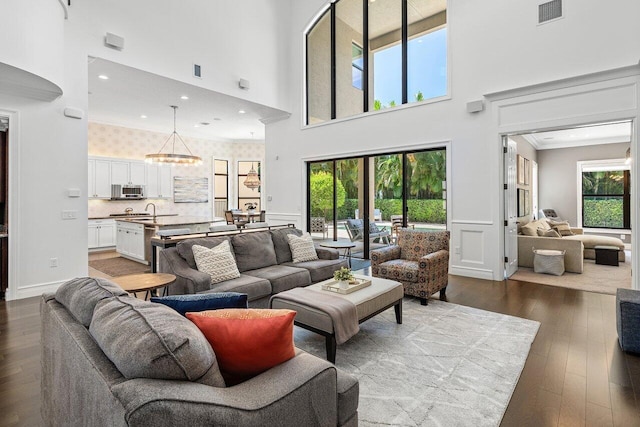 8199 Lost Creek Ln, Delray Beach, FL 33446 - living room with a high ceiling, dark wood-type flooring, ornamental molding, recessed lighting, and wainscoting