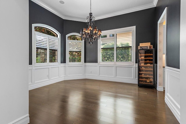 8199 Lost Creek Ln, Delray Beach, FL 33446 - unfurnished dining area featuring wine cooler, a chandelier, crown molding, a wainscoted wall, and a decorative wall