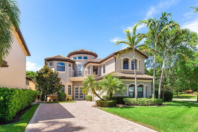 8199 Lost Creek Ln, Delray Beach, FL 33446 - mediterranean / spanish home with decorative driveway, a front yard, stucco siding, and a tiled roof