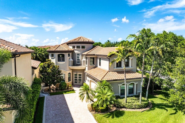 8199 Lost Creek Ln, Delray Beach, FL 33446 - mediterranean / spanish-style house featuring stucco siding, a tiled roof, decorative driveway, and a front yard