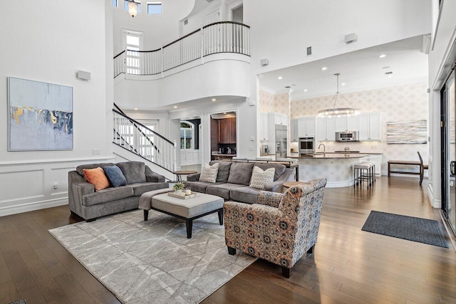 8199 Lost Creek Ln, Delray Beach, FL 33446 - living area featuring wallpapered walls, stairway, dark wood finished floors, a towering ceiling, and ornamental molding