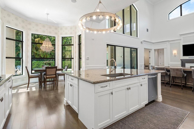 8199 Lost Creek Ln, Delray Beach, FL 33446 - kitchen with dark wood finished floors, dishwasher, light stone countertops, white cabinetry, and an island with sink