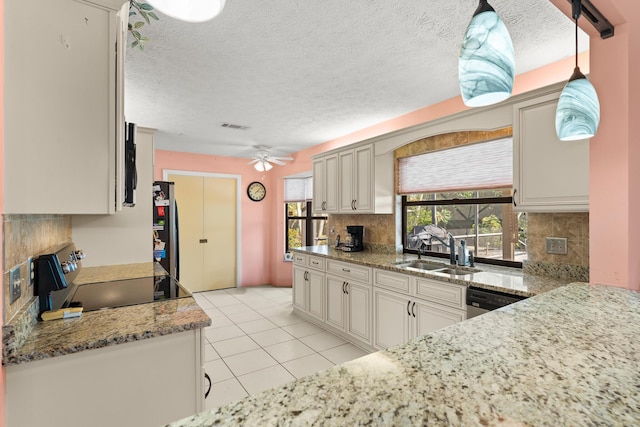 1107 SE Cambridge Dr, Port Saint Lucie, FL 34952 - kitchen featuring appliances with stainless steel finishes, decorative backsplash, a ceiling fan, light tile patterned flooring, and a fireplace