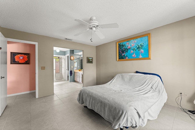 1107 SE Cambridge Dr, Port Saint Lucie, FL 34952 - bedroom featuring a textured ceiling, light tile patterned floors, ensuite bathroom, and a ceiling fan