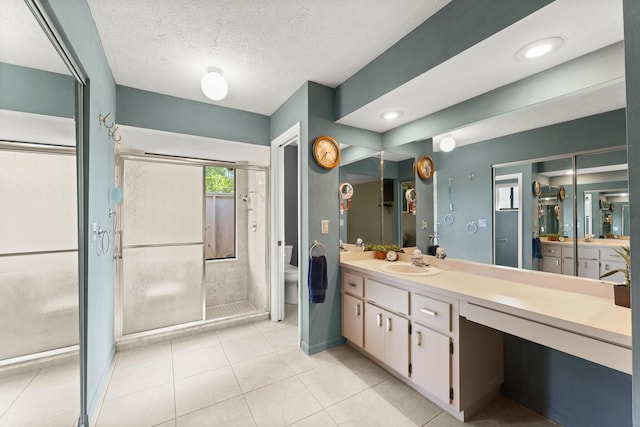 1107 SE Cambridge Dr, Port Saint Lucie, FL 34952 - bathroom with vanity, a shower stall, tile patterned flooring, and a textured ceiling