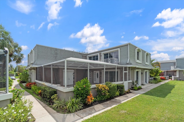 401 Vision Ct, Palm Beach Gardens, FL 33418 - back of property with mansard roof, a yard, a sunroom, and a balcony