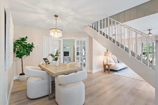 401 Vision Ct, Palm Beach Gardens, FL 33418 - dining area featuring stairs, wood finished floors, and a chandelier