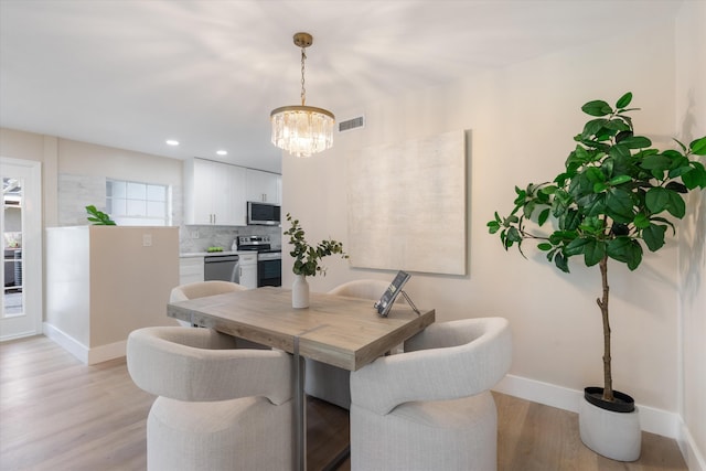 401 Vision Ct, Palm Beach Gardens, FL 33418 - dining area with a chandelier, light wood-style floors, and recessed lighting