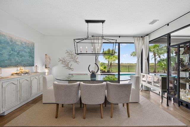31 Dunbar Rd, Palm Beach Gardens, FL 33418 - dining space featuring a chandelier, light wood-style floors, and a textured ceiling