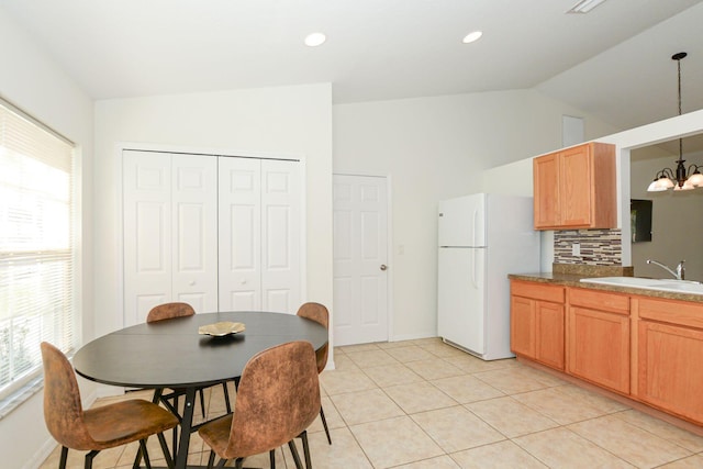 885 SW Sultan Dr, Port Saint Lucie, FL 34953 - kitchen with freestanding refrigerator, a chandelier, lofted ceiling, tasteful backsplash, and decorative light fixtures