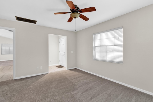 1360 39th Ave, Vero Beach, FL 32960 - unfurnished bedroom featuring carpet, ensuite bathroom, tile patterned floors, and a ceiling fan