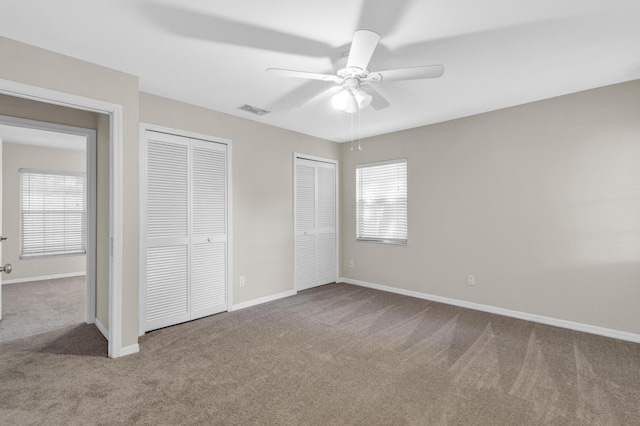 1360 39th Ave, Vero Beach, FL 32960 - unfurnished bedroom featuring carpet floors, multiple closets, multiple windows, and a ceiling fan