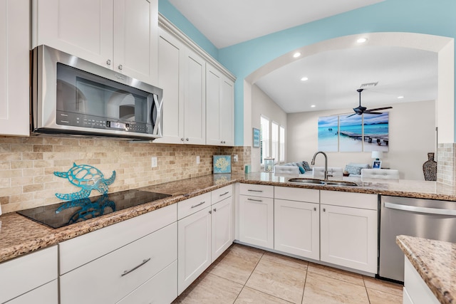 6458 SW Key Deer Ln, Palm City, FL 34990 - kitchen with appliances with stainless steel finishes, arched walkways, tasteful backsplash, white cabinetry, and a ceiling fan