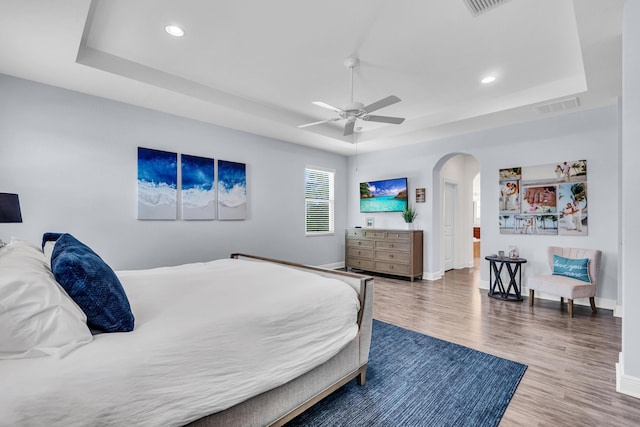 6458 SW Key Deer Ln, Palm City, FL 34990 - bedroom with a tray ceiling, arched walkways, wood finished floors, and recessed lighting