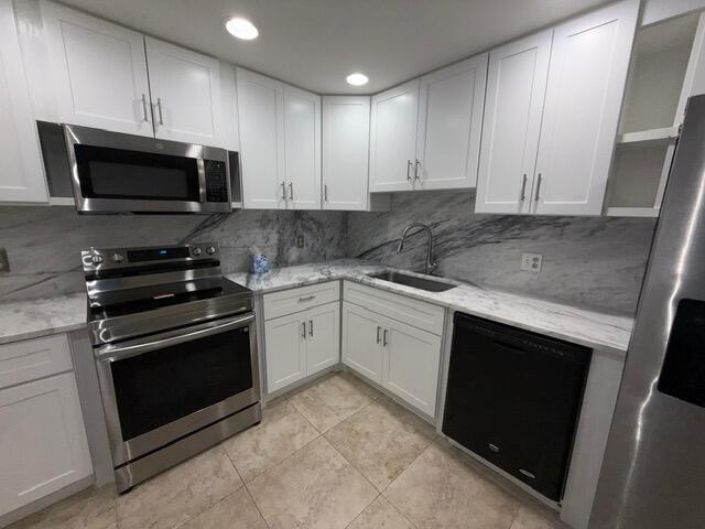 3510 Oaks Way Unit 103, Pompano Beach, FL 33069 - kitchen with stainless steel appliances, white cabinetry, light stone counters, and recessed lighting