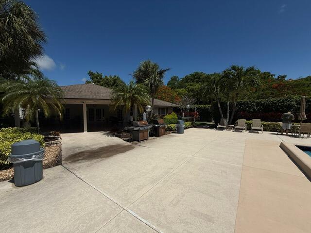 3510 Oaks Way Unit 103, Pompano Beach, FL 33069 - view of patio / terrace featuring a pool and a grill