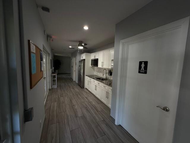 3510 Oaks Way Unit 103, Pompano Beach, FL 33069 - kitchen featuring freestanding refrigerator, black microwave, white cabinetry, dark wood-style flooring, and decorative backsplash