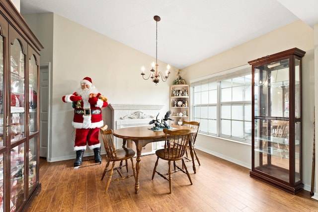 397 SW Jeanne Ave, Port Saint Lucie, FL 34953 - dining room featuring a chandelier, wood finished floors, and vaulted ceiling