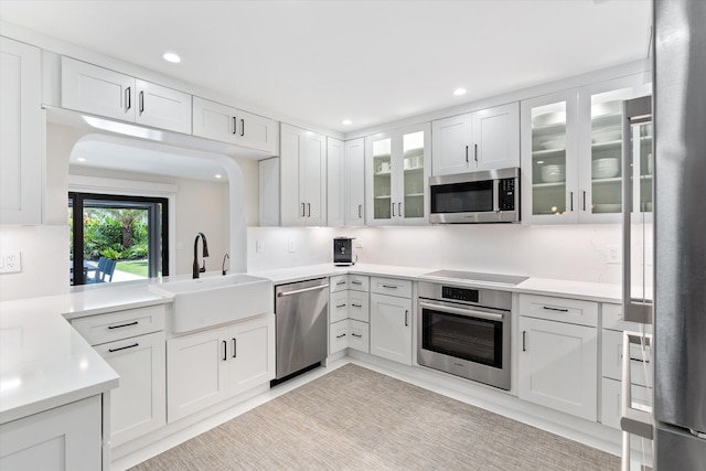 910 SW 21st St, Boca Raton, FL 33486 - kitchen with appliances with stainless steel finishes, recessed lighting, white cabinets, glass insert cabinets, and light countertops