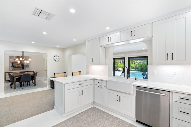 910 SW 21st St, Boca Raton, FL 33486 - kitchen with stainless steel dishwasher, arched walkways, light countertops, a chandelier, and white cabinets