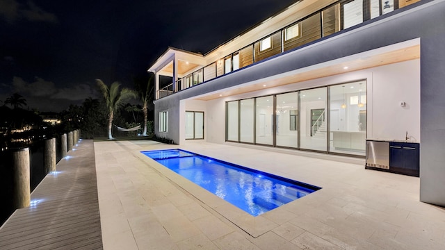 811 Chukker Rd, Delray Beach, FL 33483 - pool at night featuring a patio area and an outdoor pool