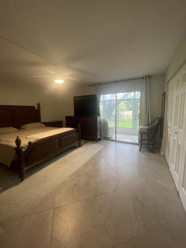 1033 Newport H Unit 1033, Deerfield Beach, FL 33442 - bedroom featuring access to exterior, ceiling fan, a textured ceiling, and light tile patterned flooring