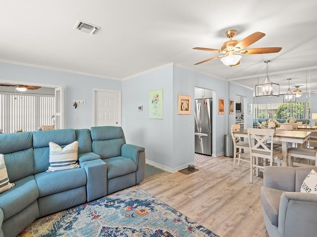 1706 Lakefront Blvd Unit D, Fort Pierce, FL 34982 - living area featuring ceiling fan, crown molding, a chandelier, and light wood-style floors