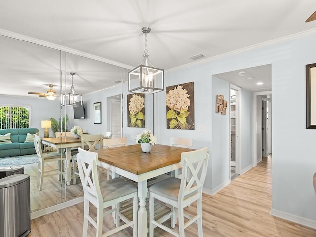 1706 Lakefront Blvd Unit D, Fort Pierce, FL 34982 - dining area with light wood-style floors, crown molding, a chandelier, and a ceiling fan