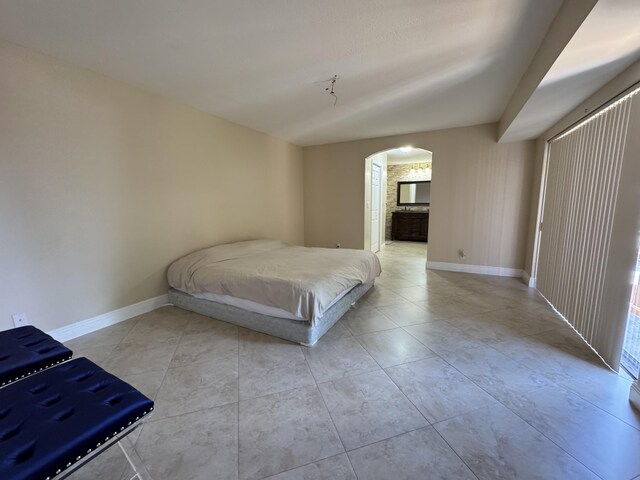 674 Springdale Cir, Palm Springs, FL 33461 - tiled bedroom with arched walkways and ensuite bath