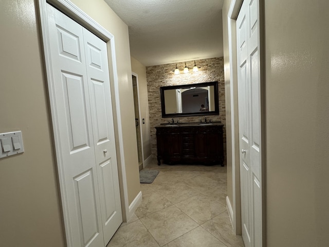 674 Springdale Cir, Palm Springs, FL 33461 - full bathroom featuring a closet, double vanity, tile patterned floors, and a textured ceiling