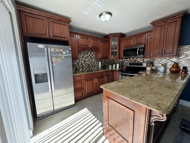 674 Springdale Cir, Palm Springs, FL 33461 - kitchen featuring appliances with stainless steel finishes, a peninsula, a kitchen breakfast bar, and decorative backsplash