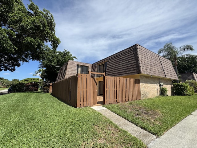674 Springdale Cir, Palm Springs, FL 33461 - view of side of home with brick siding, mansard roof, and a lawn