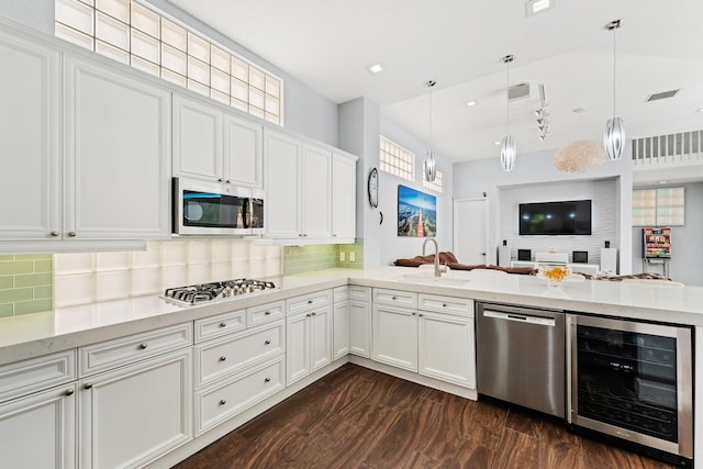 191 Sedona Way, Palm Beach Gardens, FL 33418 - kitchen with beverage cooler, stainless steel appliances, open floor plan, decorative backsplash, and white cabinets