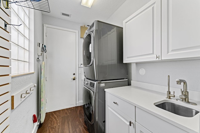 191 Sedona Way, Palm Beach Gardens, FL 33418 - laundry area with stacked washer / dryer, cabinet space, and dark wood-style flooring