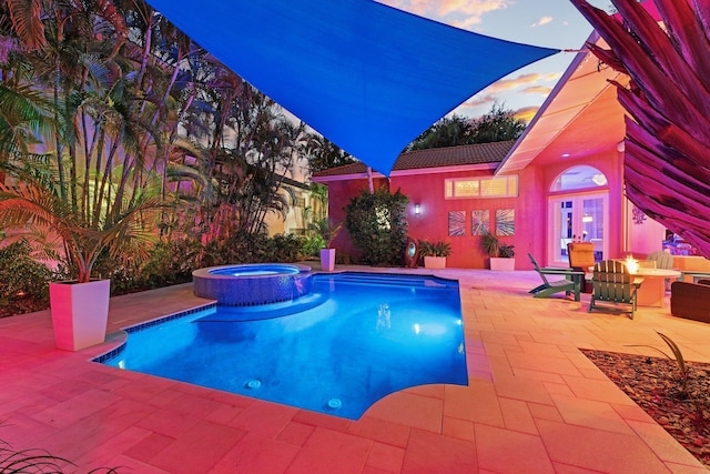191 Sedona Way, Palm Beach Gardens, FL 33418 - pool at dusk featuring a patio area, a pool with connected hot tub, and a fire pit