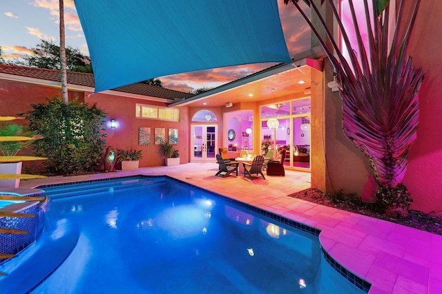 191 Sedona Way, Palm Beach Gardens, FL 33418 - pool at dusk with french doors, an outdoor pool, and a patio