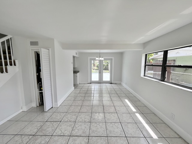 5163 Marion Pl, West Palm Beach, FL 33407 - unfurnished room featuring a chandelier, light tile patterned floors, and stairs