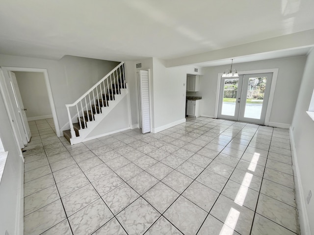 5163 Marion Pl, West Palm Beach, FL 33407 - unfurnished living room featuring stairs, light tile patterned floors, a chandelier, and french doors