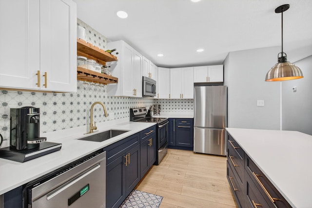 826 Cochran Dr, Lake Worth Beach, FL 33461 - kitchen with stainless steel appliances, white cabinetry, light countertops, open shelves, and light wood finished floors