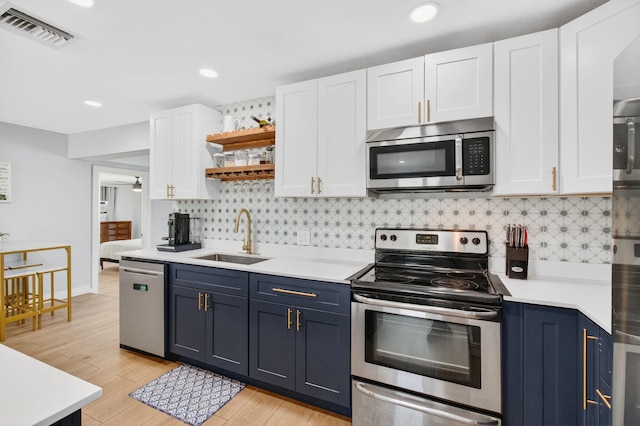 826 Cochran Dr, Lake Worth Beach, FL 33461 - kitchen featuring stainless steel appliances, open shelves, blue cabinets, white cabinetry, and light countertops