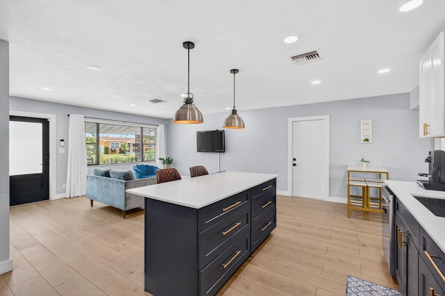 826 Cochran Dr, Lake Worth Beach, FL 33461 - kitchen with light countertops, light wood-style flooring, recessed lighting, and white cabinetry