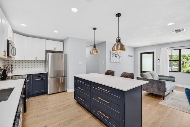 826 Cochran Dr, Lake Worth Beach, FL 33461 - kitchen with stainless steel appliances, white cabinets, light countertops, light wood-style floors, and recessed lighting