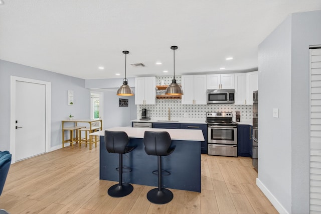 826 Cochran Dr, Lake Worth Beach, FL 33461 - kitchen featuring stainless steel appliances, white cabinetry, light countertops, decorative backsplash, and recessed lighting