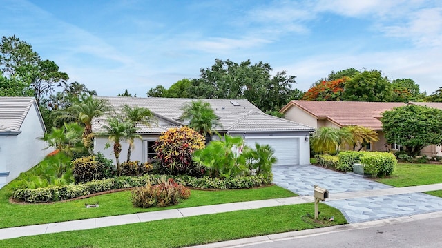 8291 Lake Cypress Rd, Lake Worth, FL 33467 - view of front of property with a tiled roof, an attached garage, driveway, and a front yard